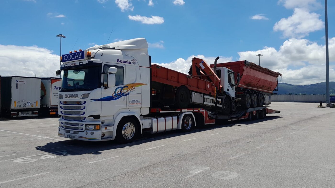 Camión góndola Cocabi transportando maquinaria pesada en puerto